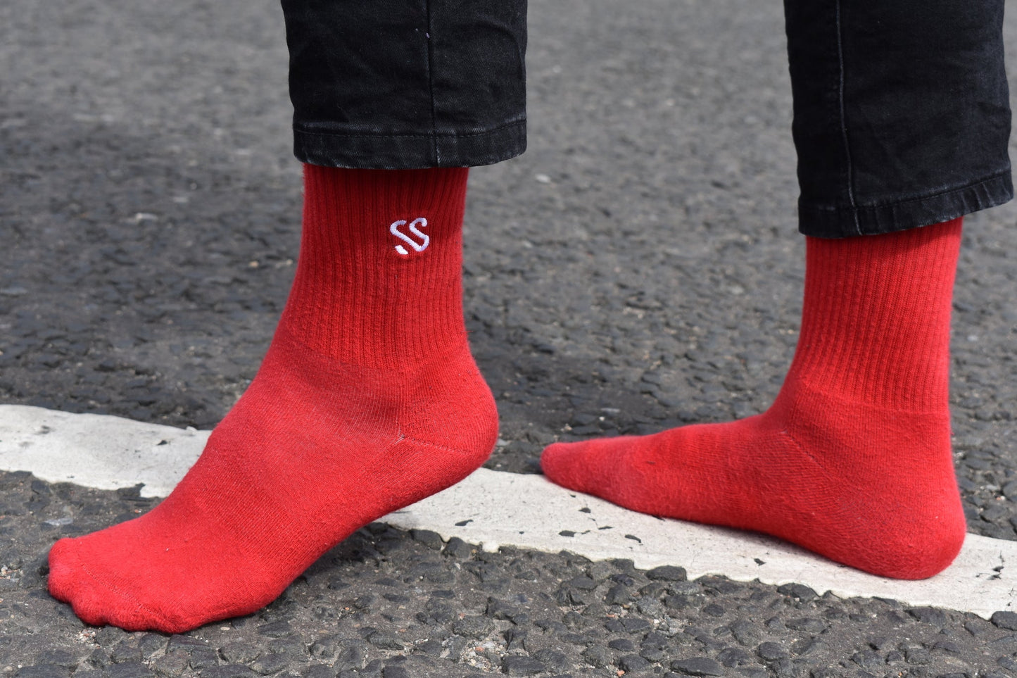 Crew length red combed cotton socks being worn outside