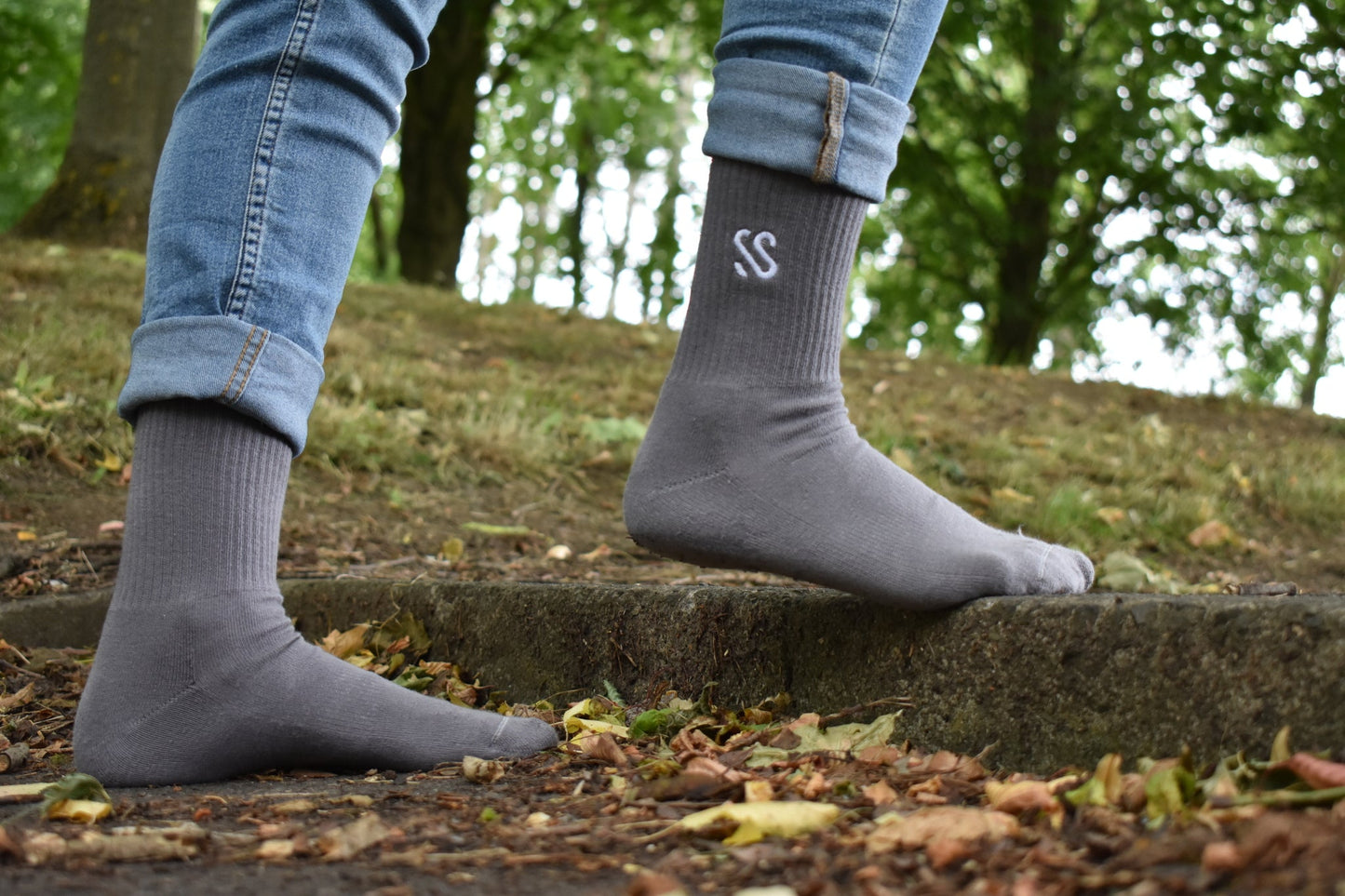 A pair of combed cotton grey socks being worn outside